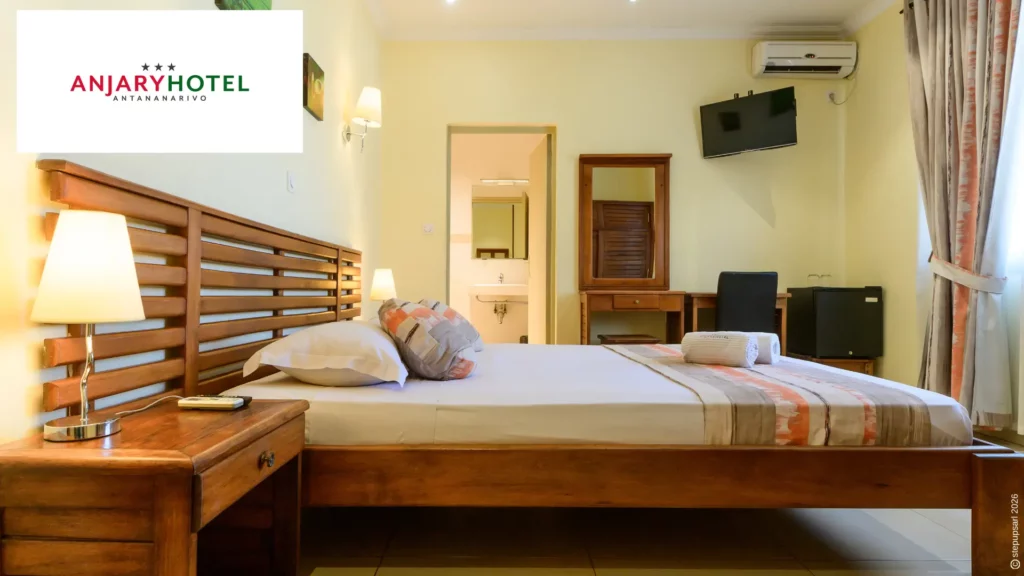 Chambre double spacieuse et lumineuse avec mobilier en bois et climatisation chez Anjary Hôtel, votre hôtel à Antananarivo centre-ville