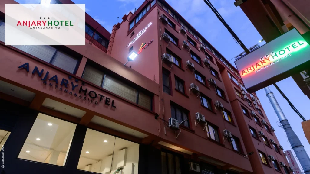 Vue extérieure nocturne de la façade et de l'enseigne lumineuse d'Anjary Hotel dans le centre-ville d'Antananarivo