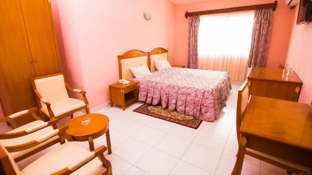 Intérieur d'une chambre spacieuse de l'Anjary Hôtel Majunga avec climatisation et coin salon pour le séjour paques-mahajanga