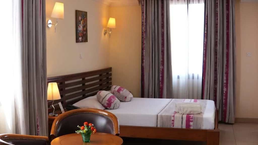 Chambre double confortable avec literie soignée et espace de travail à l'Anjary Hotel trois étoiles.