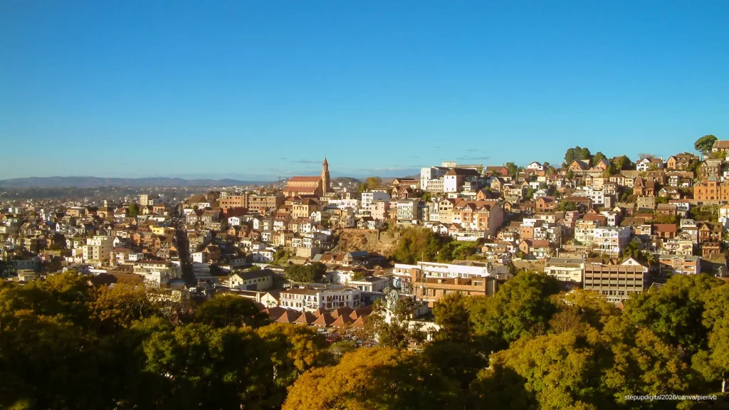 Panorama sur la haute ville d'Antananarivo, montrant les maisons colorées à flanc de colline et une église historique à visiter dominant le paysage urbain.